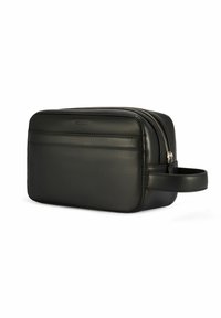 Czarna skórzana kosmetyczka o gładkiej fakturze, prostokątnym kształcie, z zamkiem błyskawicznym oraz bocznym uchwytem. Wykończona minimalistycznym przeszyciem.