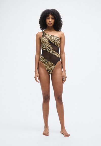 Ολόσωμο μαγιό με σχέδιο λεοπάρ και μαύρες διχτυωτές επιφάνειες. Ασύμμετρο ντεκολτέ και ψηλές ανοίξεις στα πόδια. Λείο υφή.