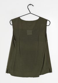 Olivgrön ärmlös topp med rund halsringning, detaljer med veck på baksidan och sidslitsar. Tillverkad av ett mjukt, lätt tyg. Hänger på en svart krok.