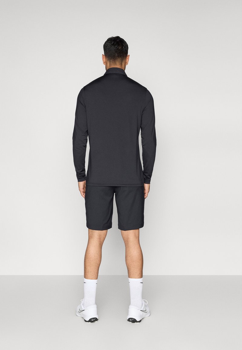 Schwarzes Langarmshirt und Shorts-Set, aus Funktionsmaterial gefertigt. Minimalistisches Design mit glatter Textur und ohne sichtbare Muster.