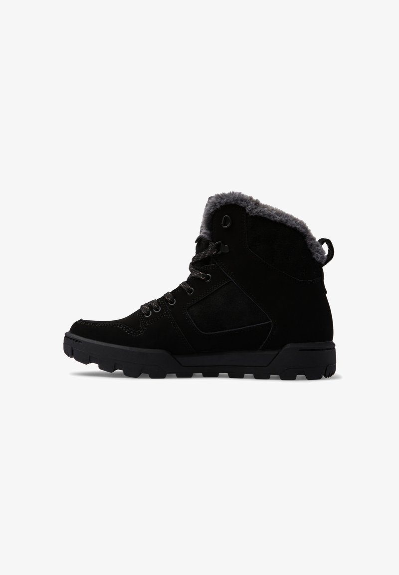 Botas de tobillo de ante negro con forro de piel de oveja gris, suela de goma texturizada negra y ojales de metal para los cordones. Detalles en los paneles laterales y diseño robusto.