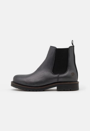 Botte Chelsea en cuir noir avec panneau latéral élastique, languette à l'arrière, talon bas empilé et semelle en caoutchouc texturée, vue de profil latéral.