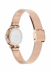 Roosa kuldne roostevabast terasest kell, millel on paindlik võrkbänd, ümar korpus ja minimalistlik nägu. Suletakse klambri abil. Märgistatud "FURLA."