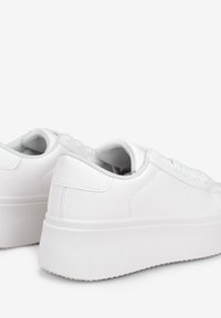 Sneaker bianche con una tomaia sintetica liscia, punta arrotondata e suola spessa. Presentano accenti grigi a contrasto sulla fodera interna e sul tallone.