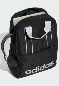 Mochila negra con acentos y logotipo blancos, que cuenta con un compartimento principal con cremallera, dos asas de transporte y correas de hombro ajustables.