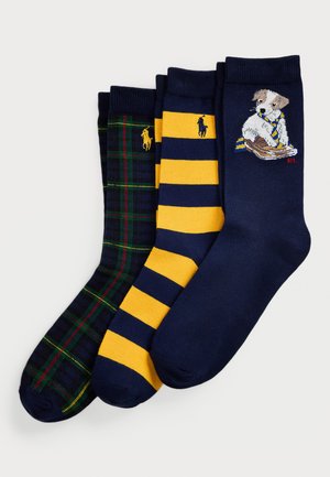 Drei Paar Crew-Socken: ein grün-blaues Karomuster, ein gelb-blau gestreift und ein marineblau mit einem Hund im Schal-Design.