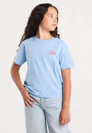 Camiseta de algodón de color azul claro con mangas cortas, que presenta un texto rojo "ESCAPE DE VERANO" y un gráfico de concha en el lado izquierdo del pecho. Corte casual.
