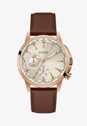 Orologio con cinturino in pelle marrone e cassa in oro rosa, quadrante crema, due sottodial e nomi delle città del mondo attorno al bezel. Presenta indicatori delle ore semplici.