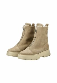 Botas de tobillo de ante beige con un suave forro de piel, cremalleras laterales y una suela de goma beige gruesa. Presentan una punta redondeada y un diseño robusto.