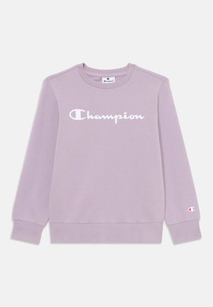 Lavender sweatshirt with ribbed crew neck, long sleeves, and a white "Champion" logo across the chest. Features logo accent on cuff.