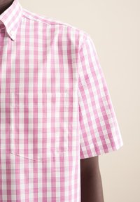 Korte mouwen, roze en witte geruite shirt met een button-down kraag. Voorzien van een borstzak. Katoenen materiaal met een soepele textuur.