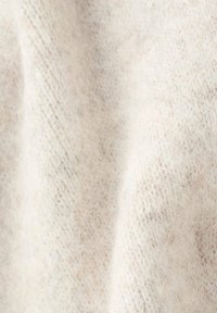 Tessuto lavorato a maglia beige chiaro con una morbida e pelosa texture. Presenta un sottile motivo a coste e una leggera lucentezza. Ideale per abbigliamento o accessori.