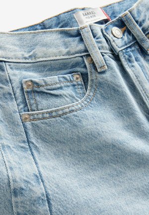 Jeans in denim azzurro chiaro a vita media, con una tasca frontale, cuciture a contrasto e accessori in metallo. Il tessuto presenta un delicato motivo testurizzato.