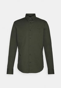 Camisa de manga larga verde oliva con cuello abotonado, cierre frontal de botones y botones negros. Fabricada con una tela suave y ligera.