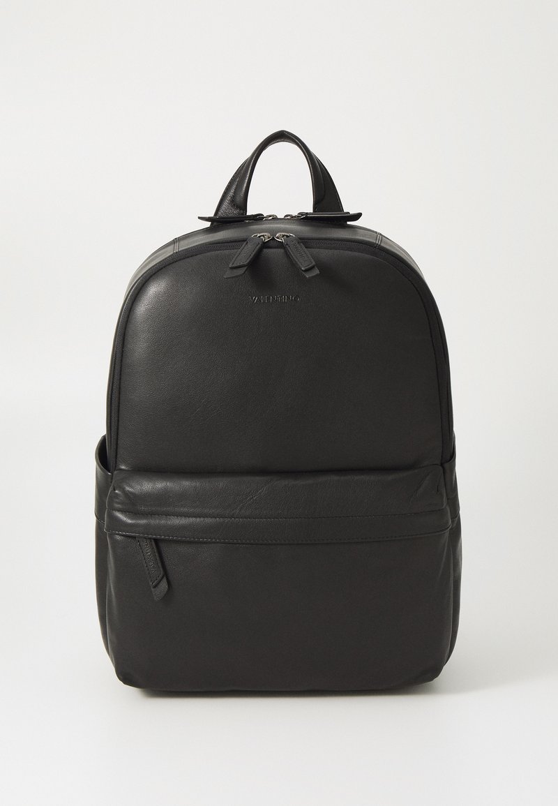 Zwarte leren rugzak met een afgeronde vorm, dubbele ritsen, een bovenhandvat en een voorvak met rits. Gladde textuur met subtiele branding.