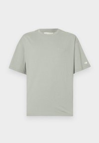 Tricou verde deschis, cu mânecă scurtă, fabricat din bumbac moale, cu guler rotund, având un mic logo alb pe piept și un patch cu logo pe mânecă.