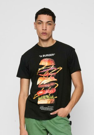 Schwarzes T-Shirt mit einem bunten Grafikmotiv eines gestapelten Burgers mit verschiedenen Zutaten. Der Text „EIN BURGER“ steht über dem Bild.