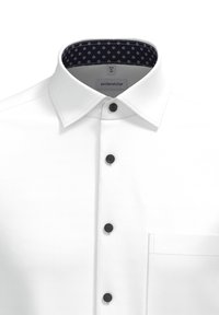 Witte button-up shirt met een gestructureerde kraag, voorzien van zwarte knopen en een marineblauw patroon aan de binnenkant van de kraag. Inclusief een borstzak.