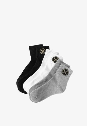 Cuatro pares de calcetines en negro, blanco y gris. Puños acanalados, mezcla de algodón, con parches circulares de logo negro en cada calcetín.