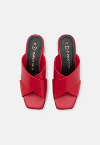 Sandales rouges à semelle plate en finition vernie, avec des brides croisées et un design à bout carré. Semelles intérieures noires avec lettrage doré. Taille 37.
