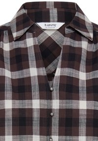 Col et devant supérieur d'une chemise à carreaux marron, noir et blanc avec trois boutons apparents de type perle et étiquette "b.young The Collection".