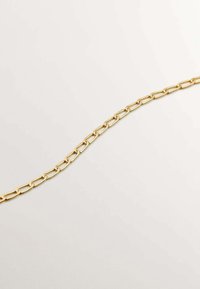 Collar de cadena de oro con eslabones ovalados alargados y un acabado liso y brillante. El diseño es sencillo y moderno, lo que realza su versatilidad.
