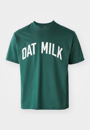 Green cotton t-shirt featuring white curved text "DAT MILK." Short sleeves and classic crew neck design with a relaxed fit.