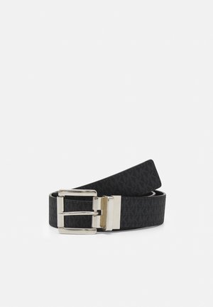 Ceinture en cuir noir avec un design texturé portant les initiales "MK". Boucle en métal argenté avec un design classique à double ardillon.
