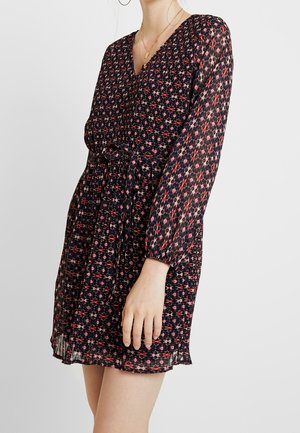 Robe à imprimé floral bleu marine avec des accents rouges et roses, dotée de manches longues, d'un corsage froncé et d'une ceinture nouée à la taille. Tissu texturé.