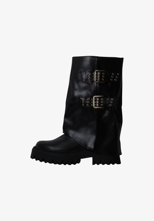 Botte mi-mollet en cuir noir avec deux larges sangles et boucles métalliques, dotée d'une semelle épaisse à crampons et d'un bout arrondi.