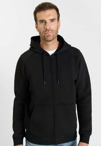 Zwarte hoodie met rits, voorzien van een capuchon, geribbelde boorden en tailleband. Gemaakt van een gladde, gestructureerde stof. Voorzien van steekzakken aan de voorkant en een trekkoord.