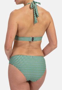 Conjunto de bikini con un patrón geométrico en verde y crema, que incluye un lazo de cuello halter, un cierre con broche ajustable y una textura de tela suave y lisa.