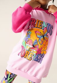 Rózsaszín kapucnis pulóver színes "Barátok örökre" felirattal, pillangókkal, virágokkal és gombákkal díszítve. Puha pamut keverék anyagból, bordázott mandzsettákkal.