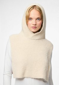Sudadera cropped beige con capucha, hecha de un suave tejido de punto con textura acanalada y un escote ancho y drapeado. Diseño ligero, cálido y acogedor.