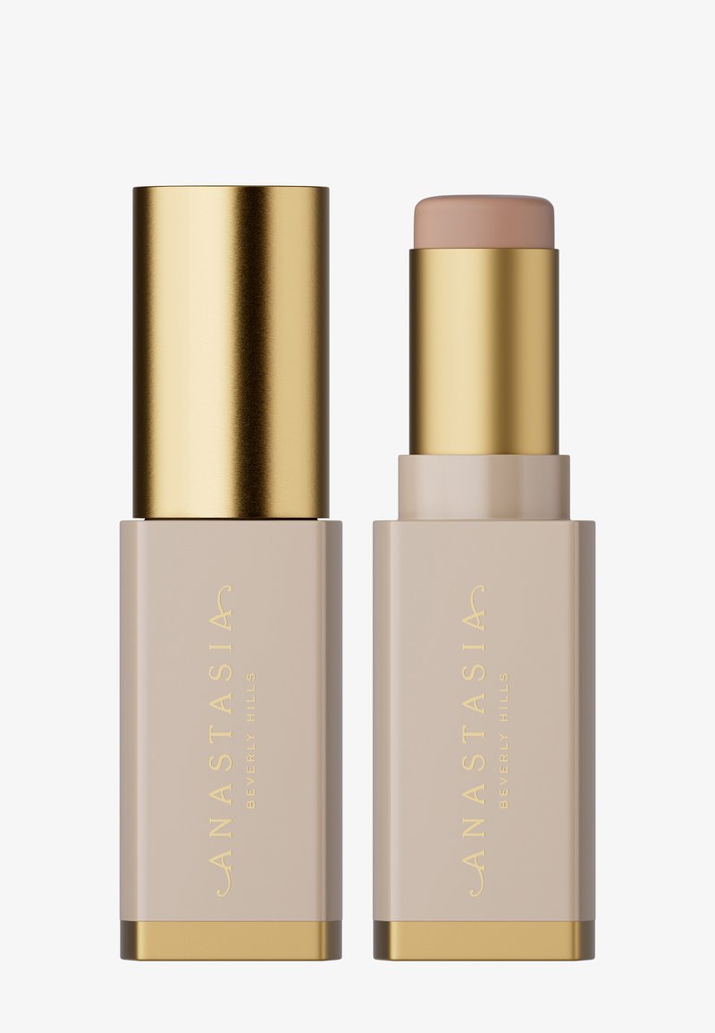 Foundation-Stick mit goldenem Deckel und Basis, mit einem beigen Röhrchen und goldener Beschriftung. Glatte Textur, minimalistisches Design.