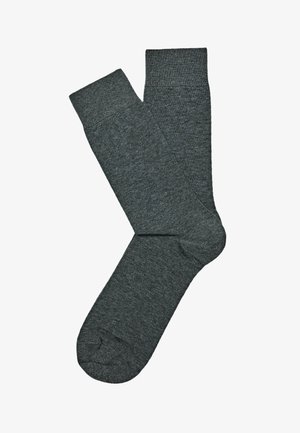 Paio di calzini semplici grigio scuro, modello crew, disposti piatti, uno sovrapposto all’altro, su sfondo bianco.