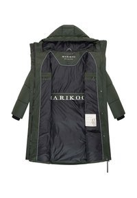 Zaļš pūkains mētelis ar kapuci, kuram ir quiltēta ārpuse, melna oderējums, vairāki iekšējie kabatas un balta logo druka iekšpusē.