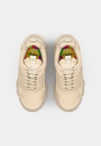 Beige sneakers with textured fabric, padded collar, and rubber sole. "Buffalo" logo on tongue and colorful insole with geometric pattern.