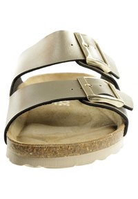 Sandalo aperto con due cinghie metalliche argentate e fibbie color oro. Suola in sughero con una superficie marrone texture e suola in gomma bianca.