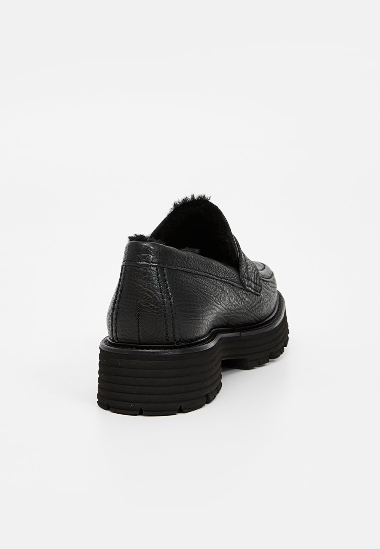 Schwarze Lederloafers mit strukturiertem Finish, ausgestattet mit einer robusten Gummisohle und einem tiefen Ausschnitt hinten, was ein lässiges, aber dennoch strukturiertes Design ergibt.