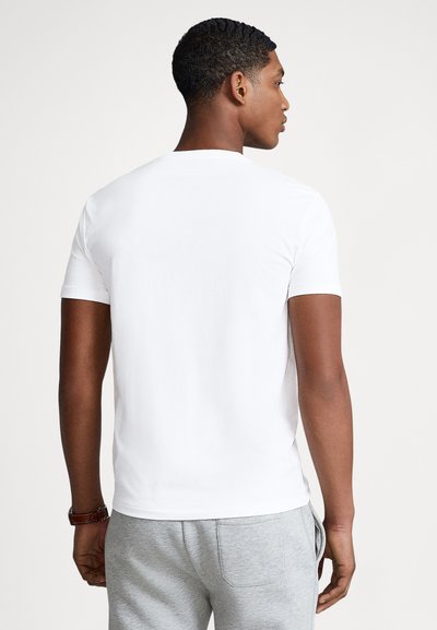 Biały t-shirt z krótkim rękawem wykonany z gładkiej bawełny, dopasowany fason, jednolity kolor, z okrągłym dekoltem i prostym przeszyciem.