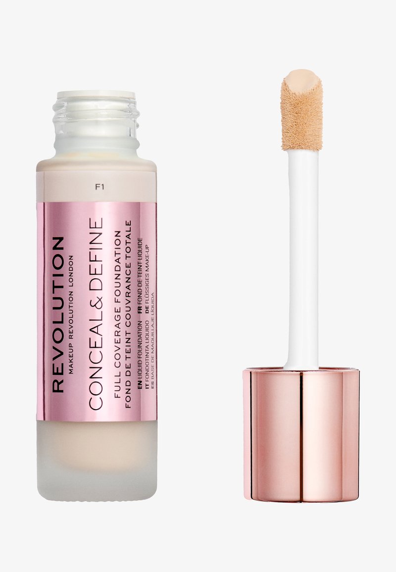 Revolution Conceal & Define foundation in a glass bottle with a beige base, pink label, and a white applicator wand with a soft tip.