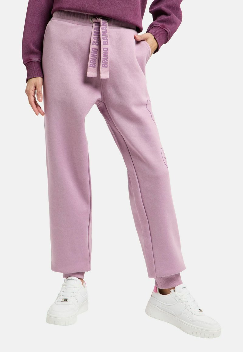 Lichte lavendelkleurige joggingbroek van zachte stof, met zijzakken, een taille met trekkoord en merkopdruk, en een rechte snit. Gecombineerd met witte sneakers.