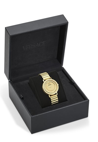 Montre-bracelet Versace en or avec cadran à motif et bracelet à maillons, présentée sur un coussin noir à l'intérieur d'une boîte noire de marque.