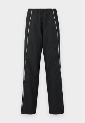 Czarne spodnie sportowe z białymi paskami po bokach, elastycznym paskiem w talii oraz logo Nike na prawej udzie, prezentowane na białym tle.