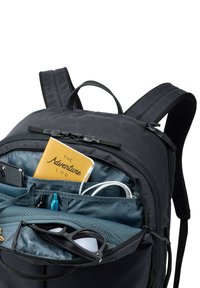 Zwarte rugzak met een ruime binnenkant, waarin een geel notitieboek, telefoon, kabels, pennen en zonnebril netjes zijn gerangschikt.