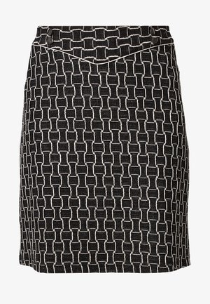 Falda hasta la rodilla en blanco y negro con un patrón geométrico tejido y un detalle en forma de V en la cintura.