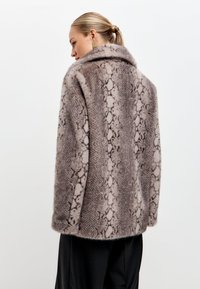 Műszőrme kabát kígyómintás mintával, szürke és bézs árnyalatokban, nagy gallérral és laza fazonnal.