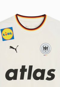Camiseta deportiva blanca con el logo negro de "Puma", un colorido cuello que incluye rojo, negro y amarillo, y una gran insignia de "LIDL" en el frente.