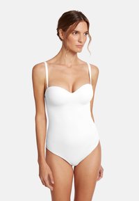 Vit baddräkt med hjärtformad halsringning och tunna justerbara axelremmar. Slät tyg och kroppsnära design framhäver en strömlinjeformad siluett.